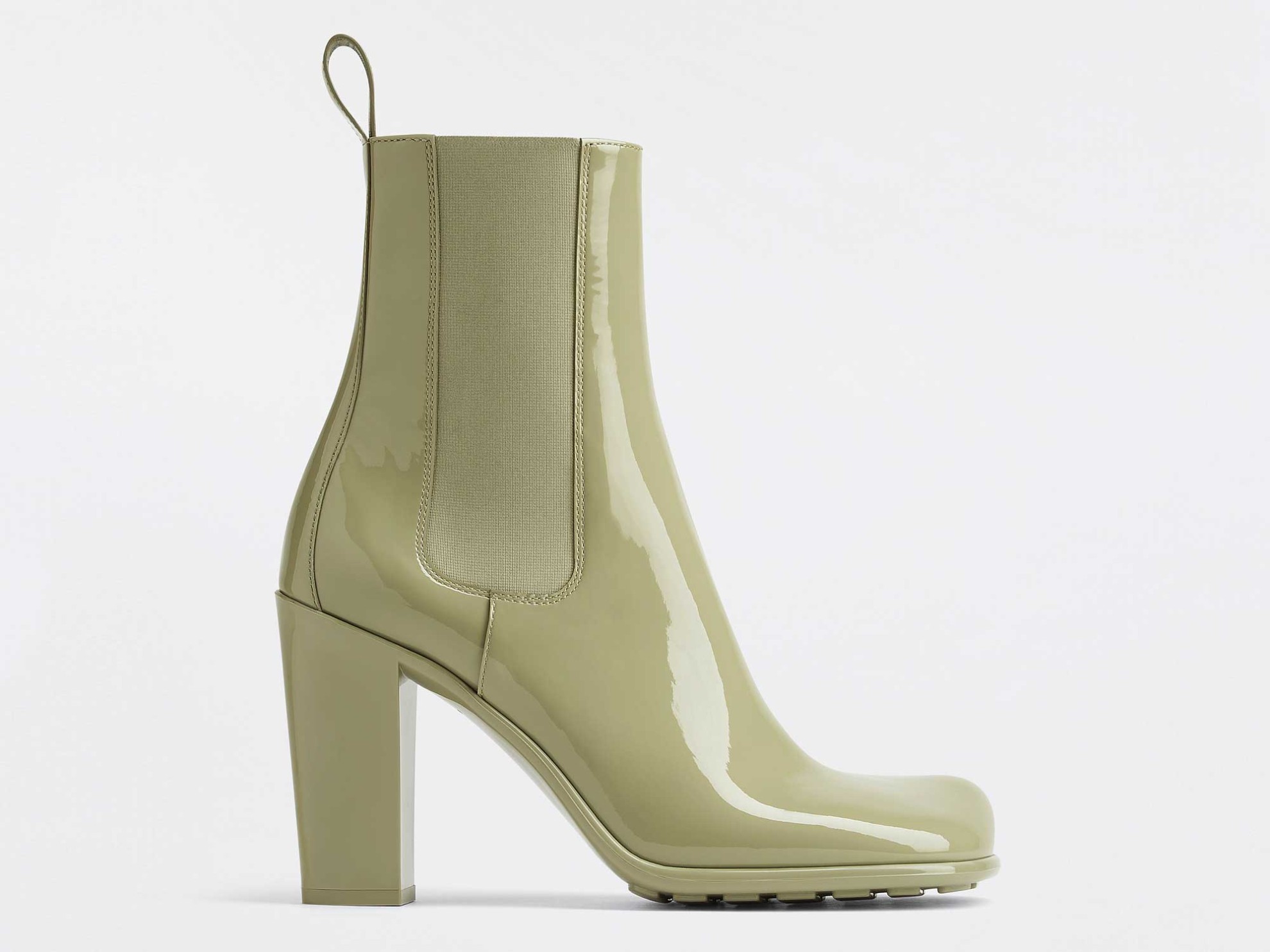High bootie made of travertine green varnished calfskin. Flat upper with lateral elastic. Thermoplastic rubber sole with a 9 cm straight heel, high and antigrip texture on the floor. BOTTEGA VENETA: Next winter booties?