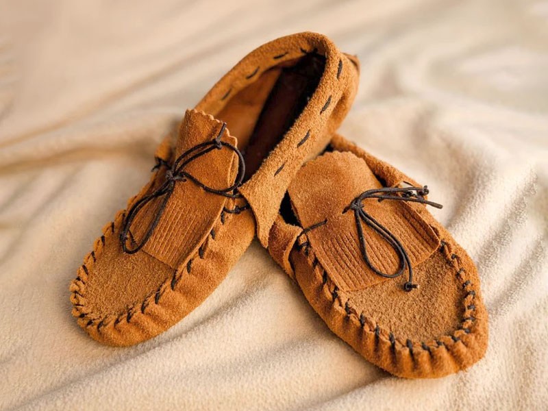 What is the origin of the gathered seam in moccasins?
